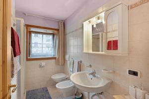 a white bathroom with a sink and a toilet at Orsa Minore in Livigno