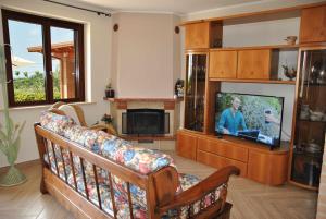 sala de estar con sofá y TV de pantalla plana en PICCOLO PARADISO vista mare in collina, en Formia