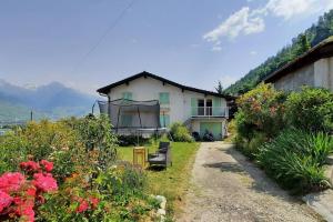 uma casa com um jardim com flores em frente em Grand appartement 6 personnes, surf, ski et randonnées em Nendaz