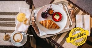 una mesa con un plato de desayuno y una taza de café en BALTAZÁR Boutique Hotel, en Budapest