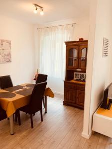 a dining room with a table and chairs and a cabinet at Apartments Casa Toni Dubrovnik in Dubrovnik