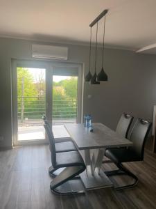 comedor con mesa, sillas y ventana en Klimatyzowany apartament z miejscem garażowym en Gorzów Wielkopolski