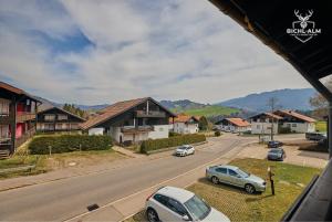 dos coches estacionados al lado de una carretera con casas en Chalet Gipfelglück, en Oberstaufen