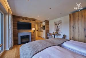 a bedroom with a bed and a fireplace and a television at Chalet Gipfelglück in Oberstaufen