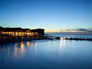 - une vue sur une étendue d'eau la nuit dans l'établissement Roda Beach Resort & Spa, à Karousádes