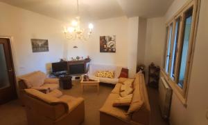 a living room with two couches and a tv at Badiaccia Village Camping in Castiglione del Lago