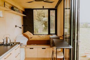 Habitación pequeña con cama y ventana en Parcel Tiny House I Ferme de Beaulieu, en Vibraye