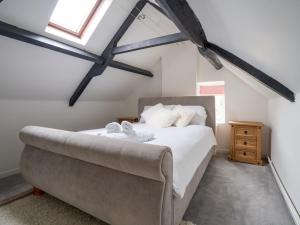 a bedroom with a large bed and a window at Pass the Keys Charming 18th Century 4 bedroom cottage in Moreton in Marsh