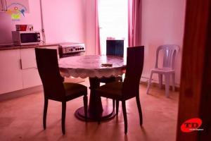 kuchnia ze stołem i 2 krzesłami oraz stołem i krzesłami w obiekcie Résidence aladin w mieście Hammamet Sud