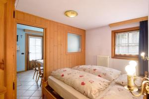 1 dormitorio con cama, mesa y ventana en Orsa Maggiore, en Livigno