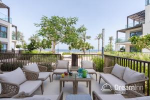 une terrasse avec des canapés et une table en face d'un bâtiment dans l'établissement Dream Inn Apartments - Address Beach Residence Fujairah, à Fujaïrah