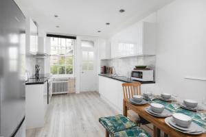 a kitchen and dining room with a table and chairs at **Authentic & Spacious 5 Bed Apartment/Hyde Park** in London