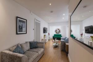 **Authentic & Spacious 5 Bed Apartment/Hyde Park** في لندن: غرفة معيشة مع أريكة وطاولة