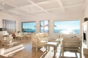 a living room with white furniture and a view of the ocean at Breakers Way Dream in Carpinteria
