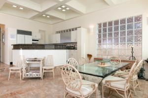 a dining room with a glass table and chairs at Breakers Way Dream in Carpinteria