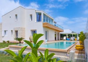 a villa with a swimming pool and a house at Villa TinaDea in Pozzallo