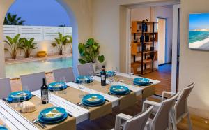 a dining room with a table and chairs with a view of the ocean at Villa TinaDea in Pozzallo