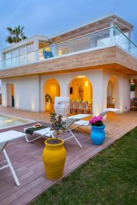 a house with a deck with chairs and a pool at Villa TinaDea in Pozzallo