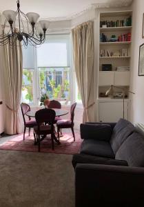 a living room with a couch and a table at Olympia W14 Two-Bedroom Apartment in London