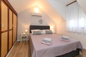 una camera da letto con un letto grande con due asciugamani sopra di Oleander Apartments Split a Spalato (Split)
