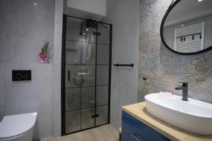 ein Bad mit einem Waschbecken und einer Dusche in der Unterkunft Morska fala, Jantar in Jantar