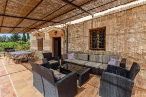 een patio met een bank, stoelen en een tafel bij YourHouse Son Morey, villa with private pool, family-friendly in Mora