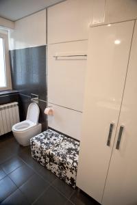 La salle de bains est pourvue de toilettes et d'une porte avec un tabouret. dans l'établissement Angel Apartment, à Belgrade