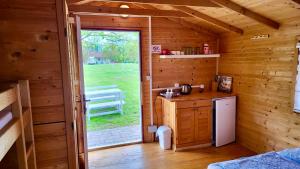 a kitchen in a wooden cabin with a door open at Una Kamp in Bosanska Krupa