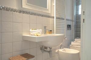 biała łazienka z umywalką i toaletą w obiekcie Roommo Viuzzo delle Canne we Florencji