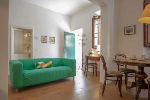 salon z zieloną kanapą i stołem w obiekcie Roommo Viuzzo delle Canne we Florencji