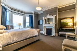 een slaapkamer met een kingsize bed en een open haard bij Ryan Mansion in St. John's