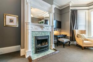 a living room with a fireplace with a chair and a desk at Ryan Mansion in St. John's