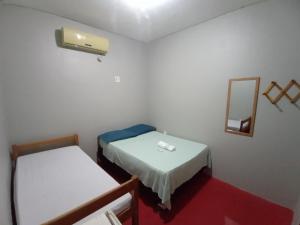 um pequeno quarto com 2 camas e um espelho em Discovery hostel em Manaus