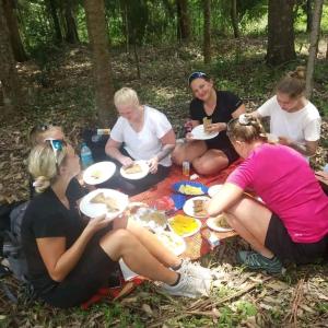 a group of women sitting around a picnic blanket at Galapagos Homestay in Lushoto