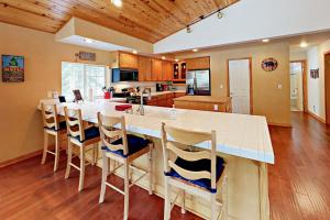 uma cozinha com uma grande ilha branca com cadeiras em Gold Dust Escape em South Lake Tahoe