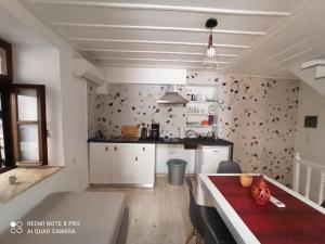 cocina con mesa roja en una habitación en Casa Topane, en La Canea