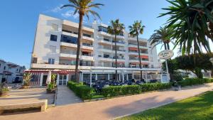 un gran edificio con palmeras delante en Apartamento Puerto Blanco, en Caleta de Vélez