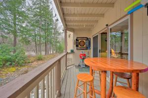 a porch with a wooden table and stools at Riverfront Retreat with Deck 1 Mi to Loon Mtn! in Lincoln