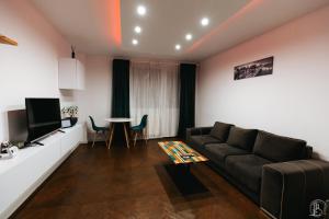 - un salon avec un canapé et une table dans l'établissement ZAZA Apartament - central area, with balcony, à Târgu Jiu