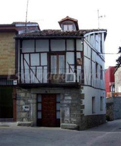 a building with a balcony on top of it at Casa Rural Frutos in San Esteban de la Sierra