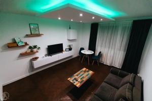 a living room with a couch and a tv and a table at ZAZA Apartament - central area, with balcony in Târgu Jiu