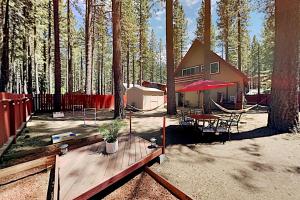 une maison dans les bois avec une table et une tente dans l'établissement Genoa Haven, à South Lake Tahoe