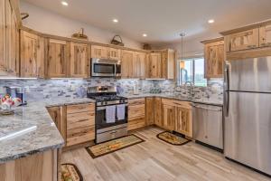 una cocina con armarios de madera y electrodomésticos de acero inoxidable en Picturesque Palisade Home Mt Garfield Views!, en Palisade