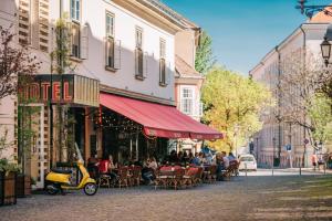 une rue avec un restaurant et un scooter garé à l'extérieur dans l'établissement BALTAZÁR Boutique Hotel, à Budapest