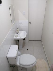 a white bathroom with a toilet and a sink at YLLARICH in Trujillo +18 photos