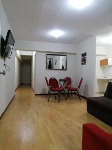 a living room with a table and chairs and a couch at YLLARICH in Trujillo