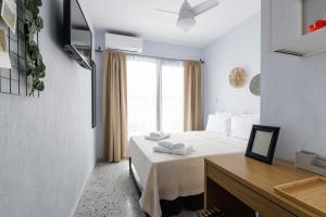 a bedroom with a bed and a desk and a window at Boho Rooms in Thessaloniki