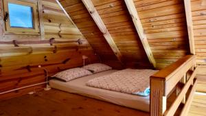 a bed in a wooden room in a log cabin at Una Kamp in Bosanska Krupa