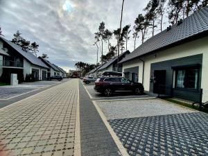 a street with a car parked in a driveway at Horizon Park Carlo Rossi in Dziwnówek +10 photos