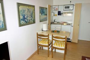 una piccola cucina con tavolo e due sedie di Residenz 24 a Duhnen